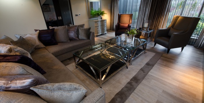 Living room contemporary Interior Design with bespoke sofa, arm chairs, table units and blinds in deep colours.